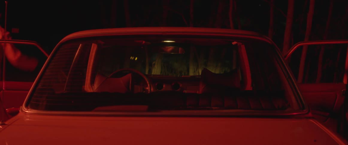 A man and woman exit a car and start dancing