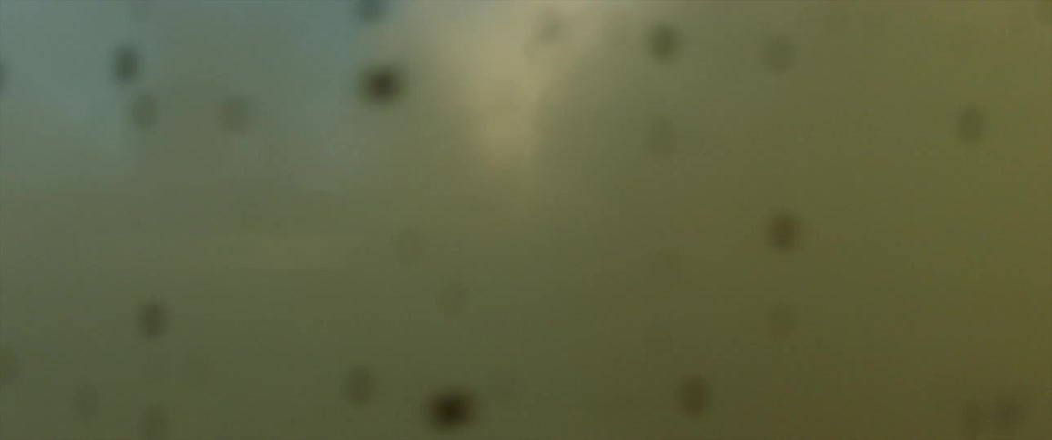 A car races along a desert plain towards a mountain as it sprays sand and dust in its wake