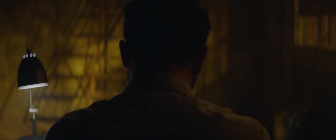 A man works at a desk in a dark room