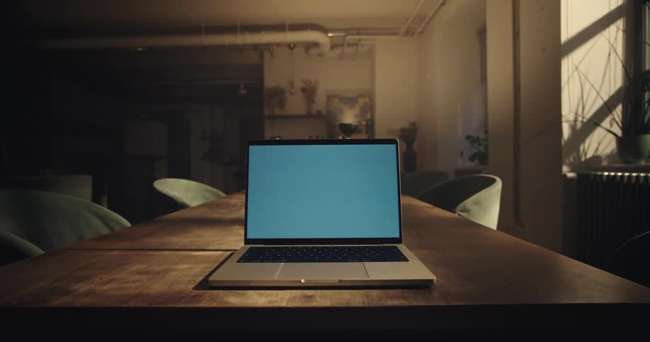 Laptop center screen in a stylish setting, a hand closes the lid