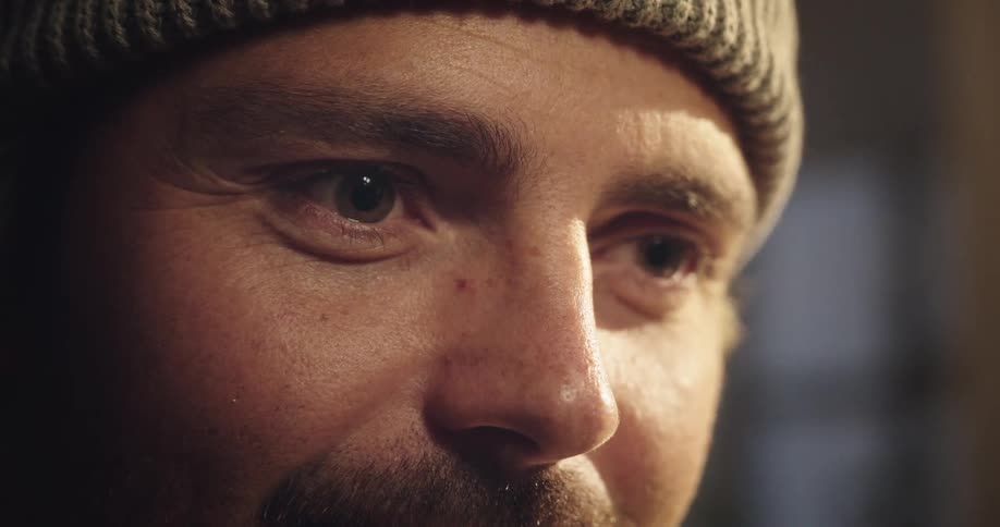 Close up of man with beanie looking at a screen