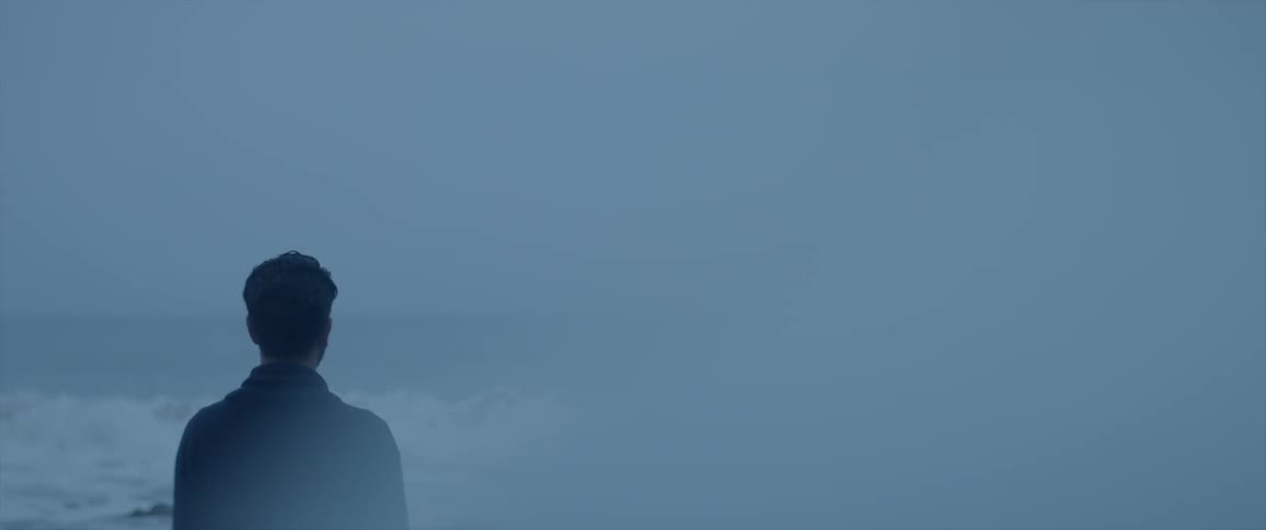 Man standing on a beach on a foggy day