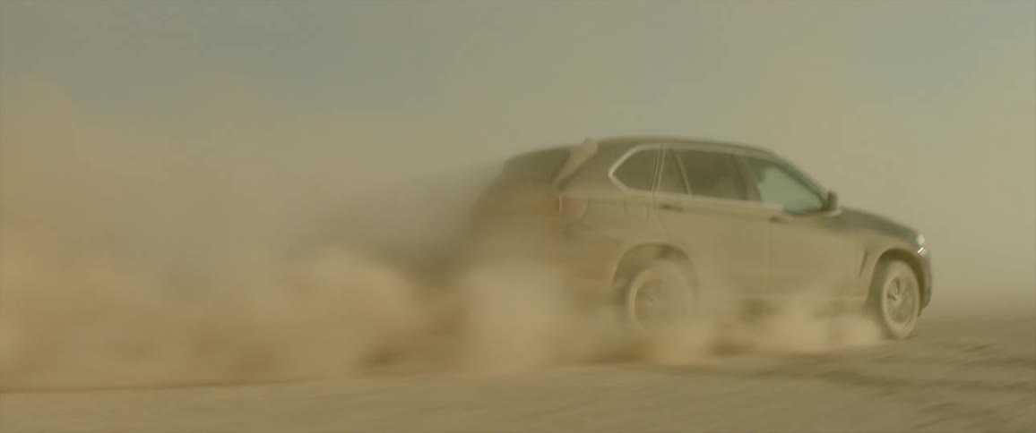 Car is speeding across dirt creating dust clouds