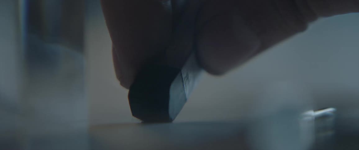 Person draws a line on a white paper with black pastel pencil