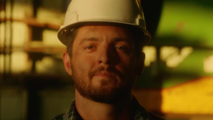 Bearded man wearing a white hard hat looking into the camera
