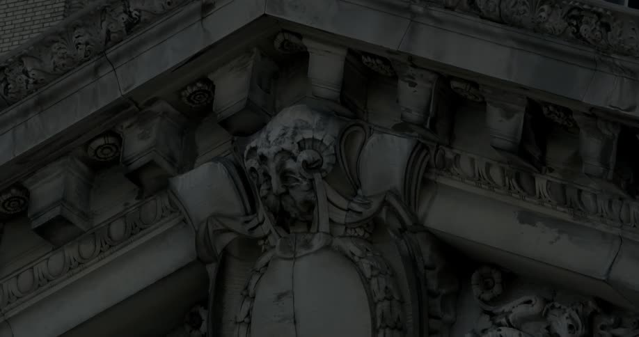 Stone sculptures hang above a building doorway