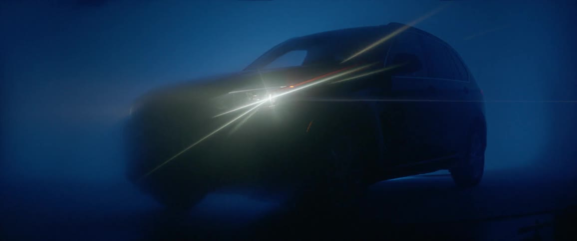 A car's headlight turns on in a misty area