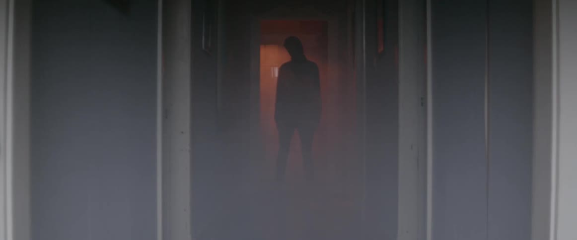 Person stands in a hallway with flashing lights