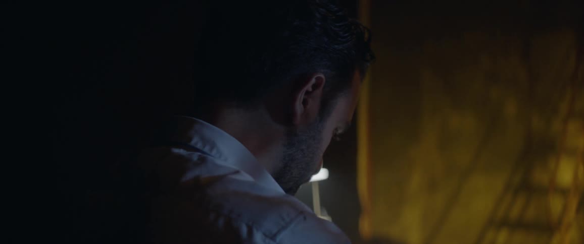 Man works at a desk in a dark room
