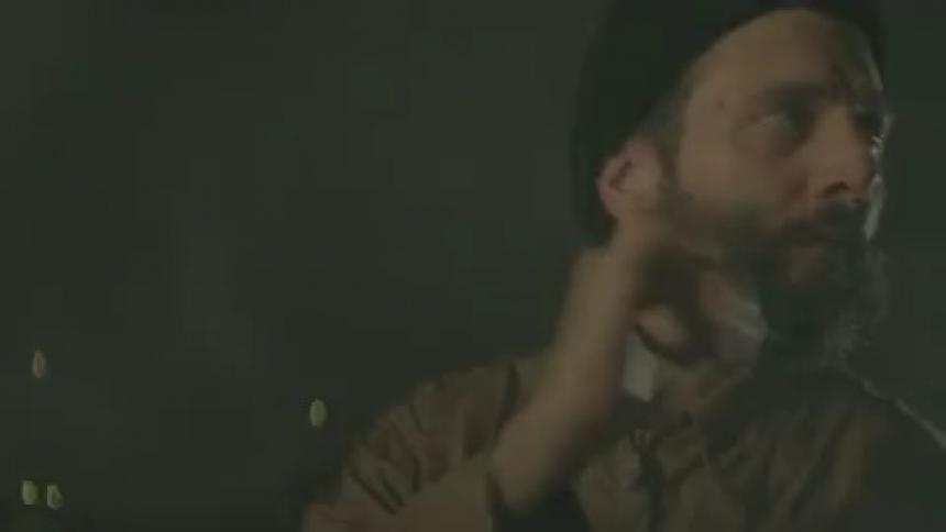 Bearded man dancing in a dark area with some flashing lights