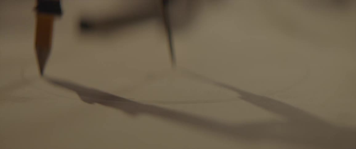 Person drawing a circle on paper with drawing compass