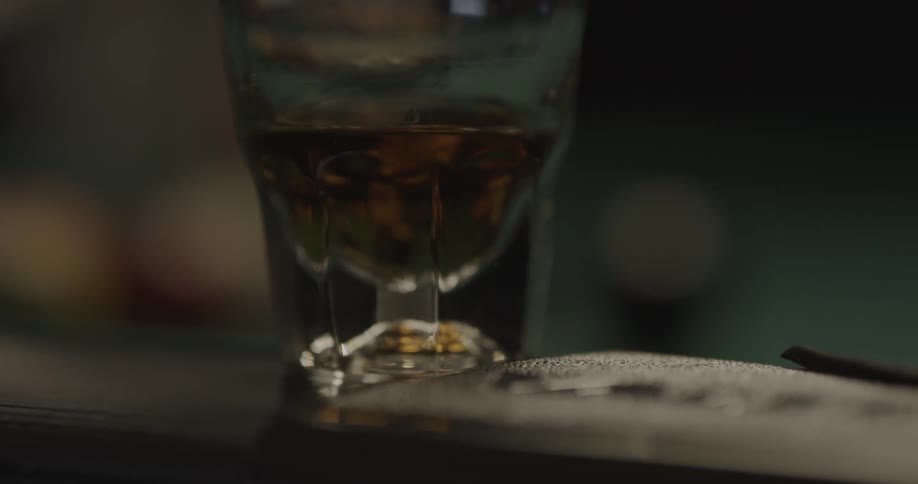 A glass with liquor sits on the counter