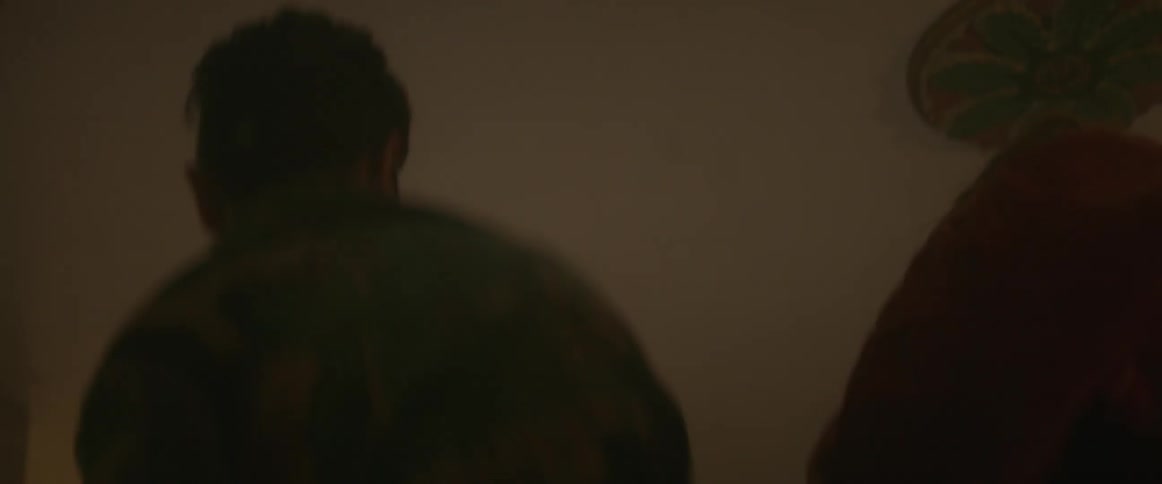 A man and woman jump up and down with flashlights in a dark room