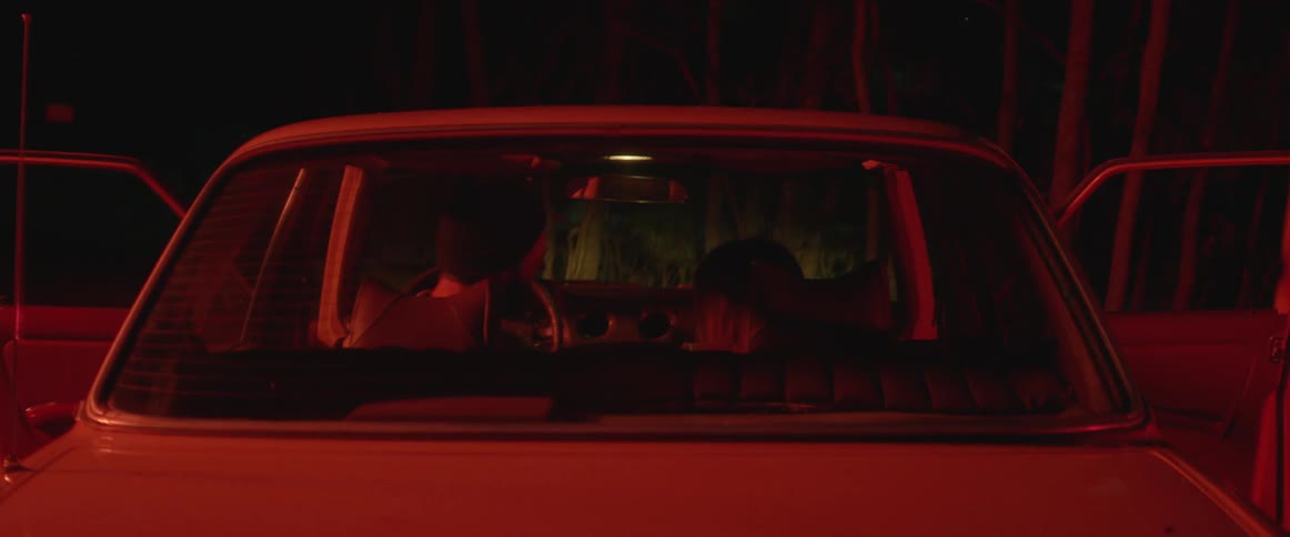 A man and woman sit in a car