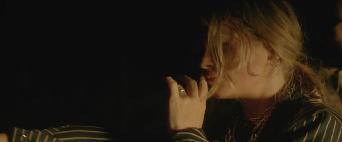 Woman dances in a dark room with a flashing light