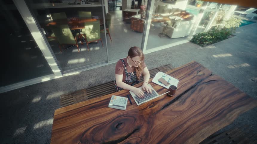 The woman opens her laptop and begins typing