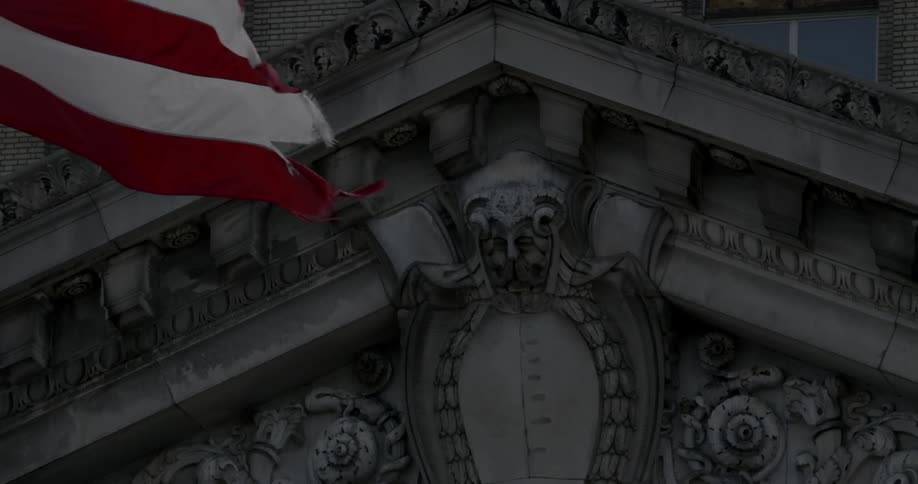 American flag flaps in the wind near mural on building