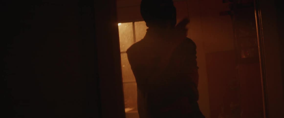 Person dancing in a dark room with lights flashing while they wear a dark ski mask