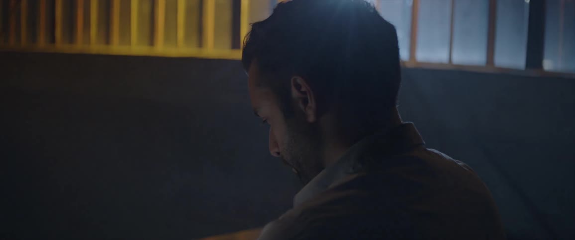 Man sits in the dark looking down