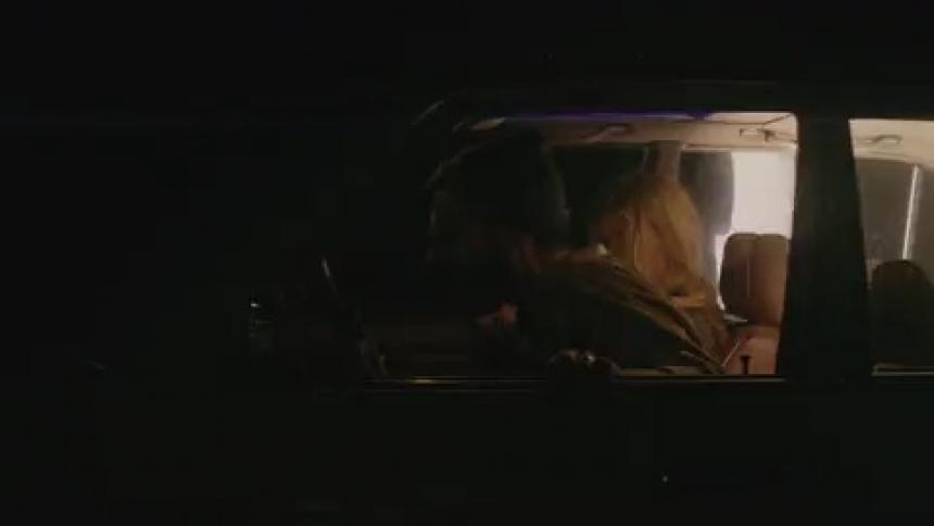 Flashing lights show two people sitting in a car