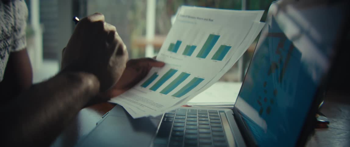 Person analyzing printed and digital charts