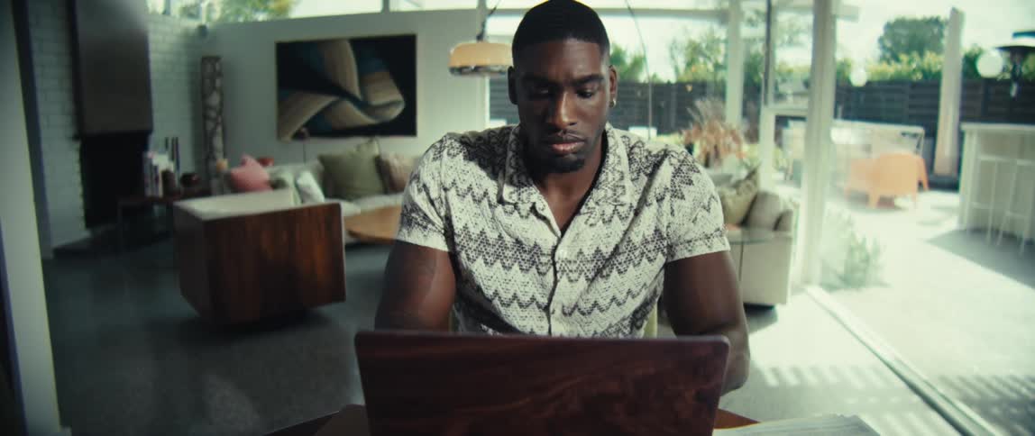 The man thinks for a moment then starts typing on the laptop