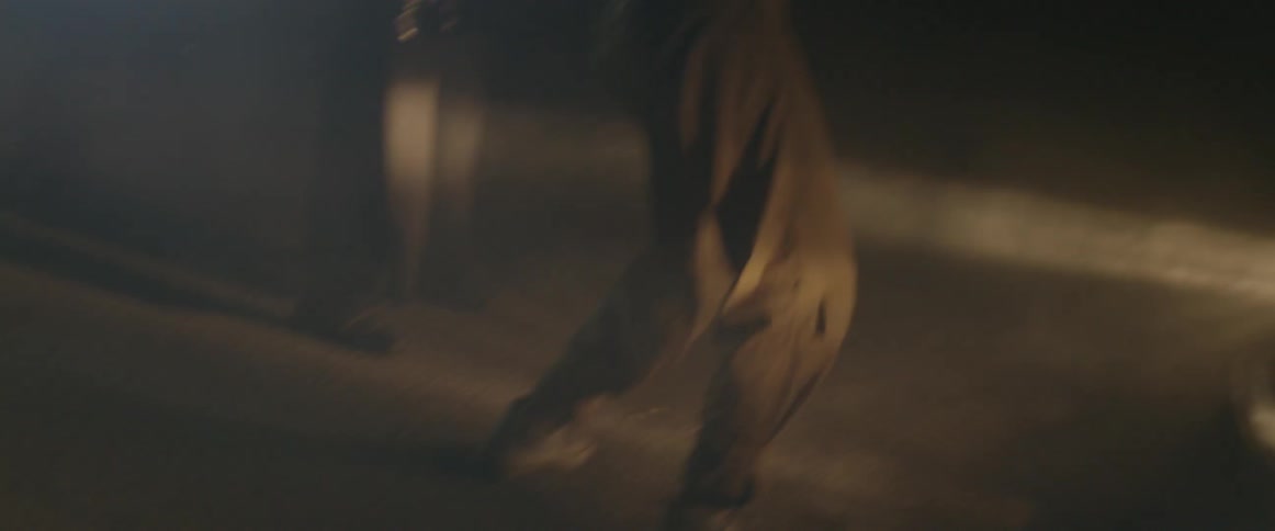 A man dances in a warehouse