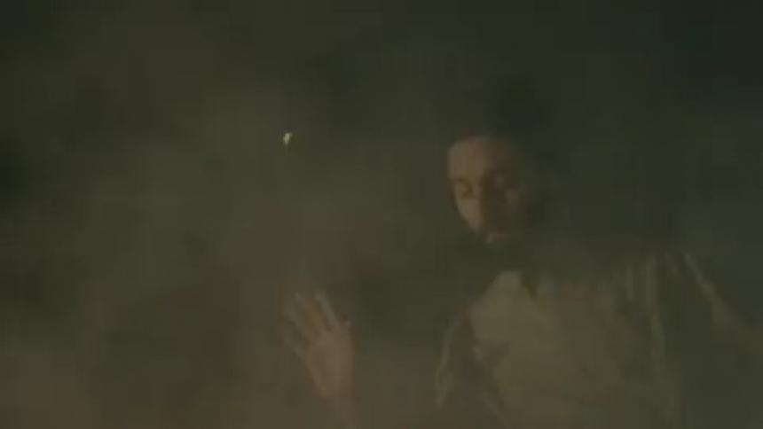 Man dancing through smoke and lights