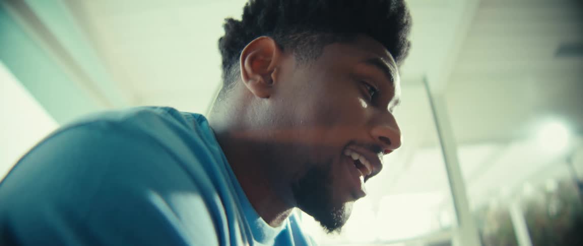 Person in blue shirt smiling in bright indoor setting