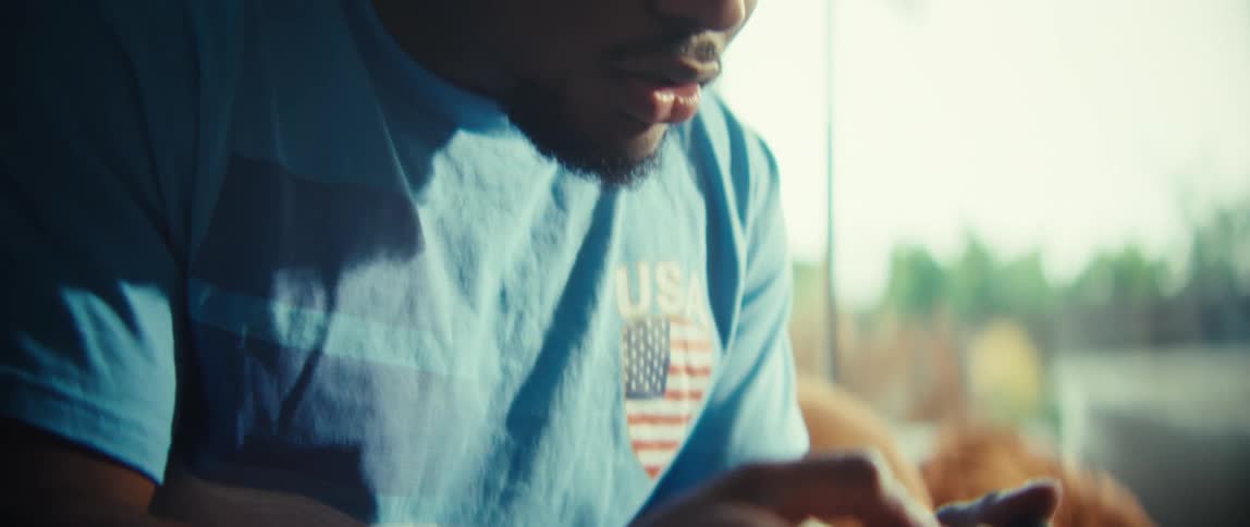 A closeup of a young man intently focused on playing a video gamehis hands move quickly over the controller as his facial expressions mirror the intensity of the gameplay