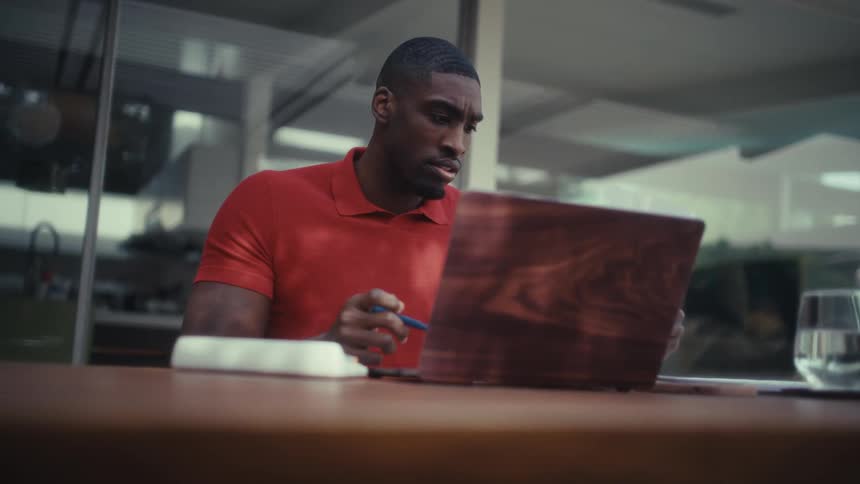The man points at paperwork in his hand with a pen