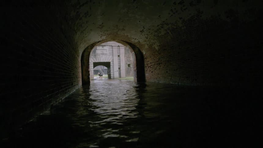 A man is pulled on a board through a narrow water tunnel