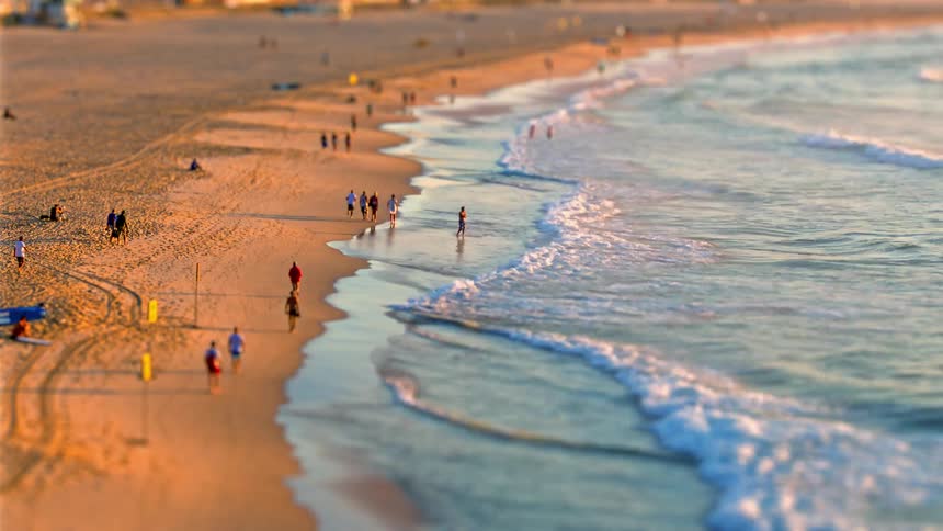 People enjoy the beach as waves roll onto the shore during the daytime