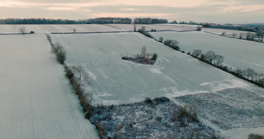 An aerial view of a landscape with snow covered fields