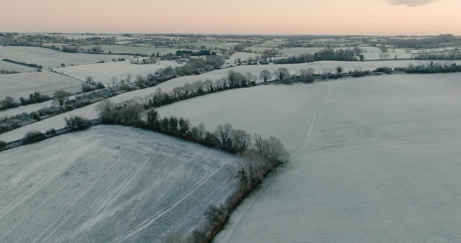 An aerial view of some grasslands covered in snow