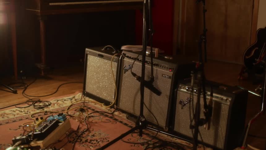 Three electric guitar amplifiers are lined up in a row in a room
