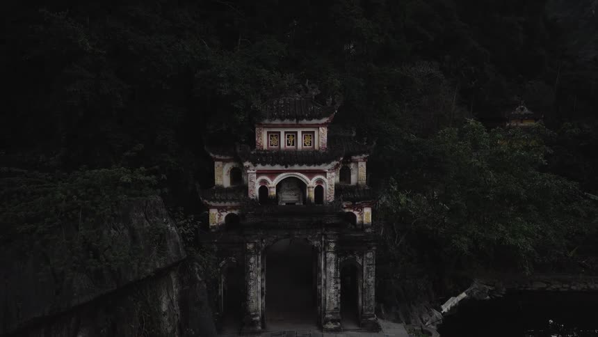 Historic building on the slope of a mountain next to a body of water outdoors during dusk or dawn