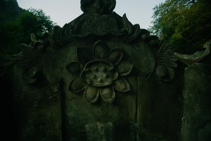 A monument statue in the woods at midday