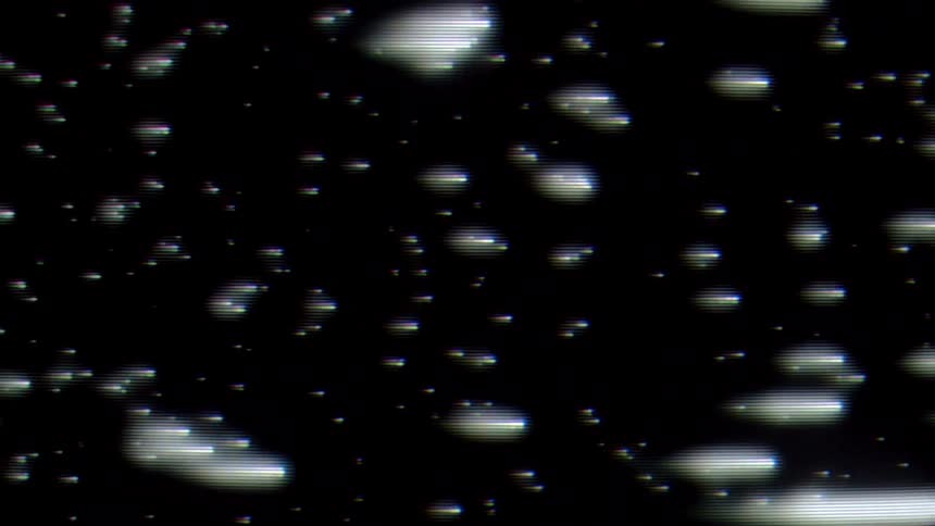 A screen displays a black background with numerous lines passing to the right