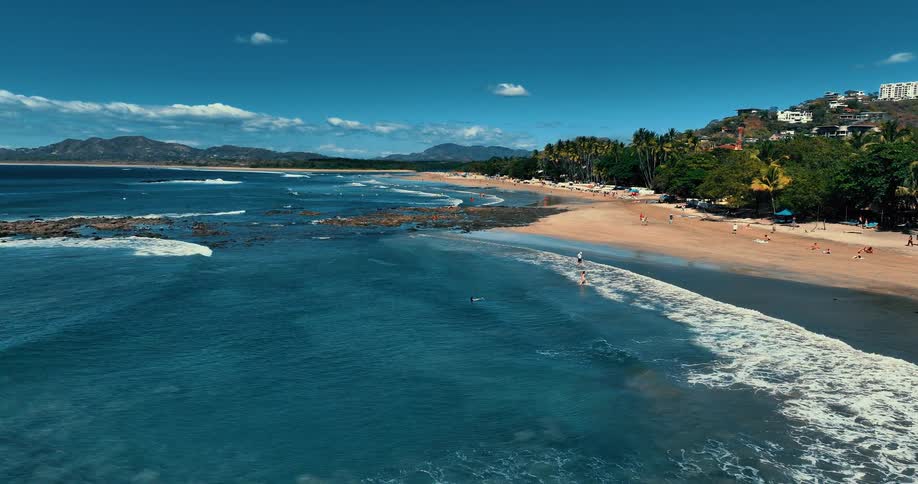 People enjoy the beach near a city during the daytime