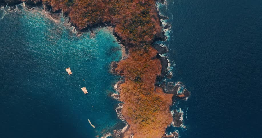 Aerial view of a narrow peninsula that is lined on both sides by ocean water