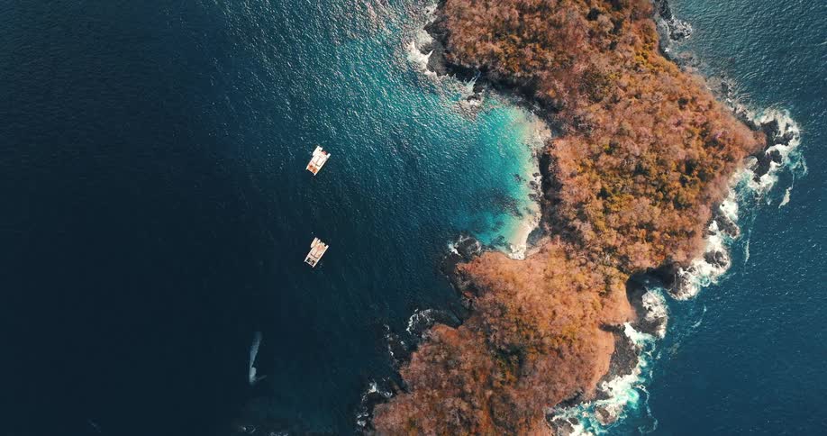 Boats are anchored by the small island