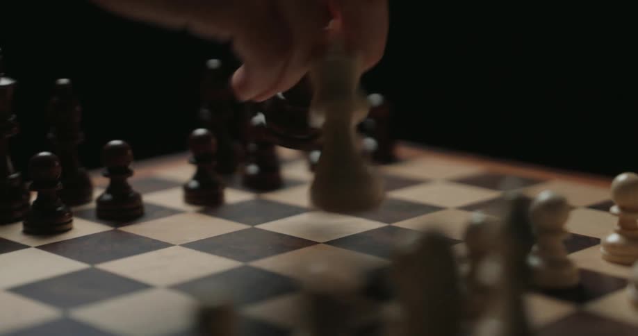 A person moves their chess piece and captures a piece from their opponent