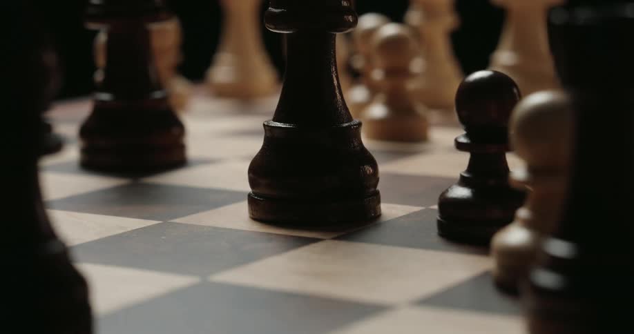 Closeup of a person taking a pawn while playing chess