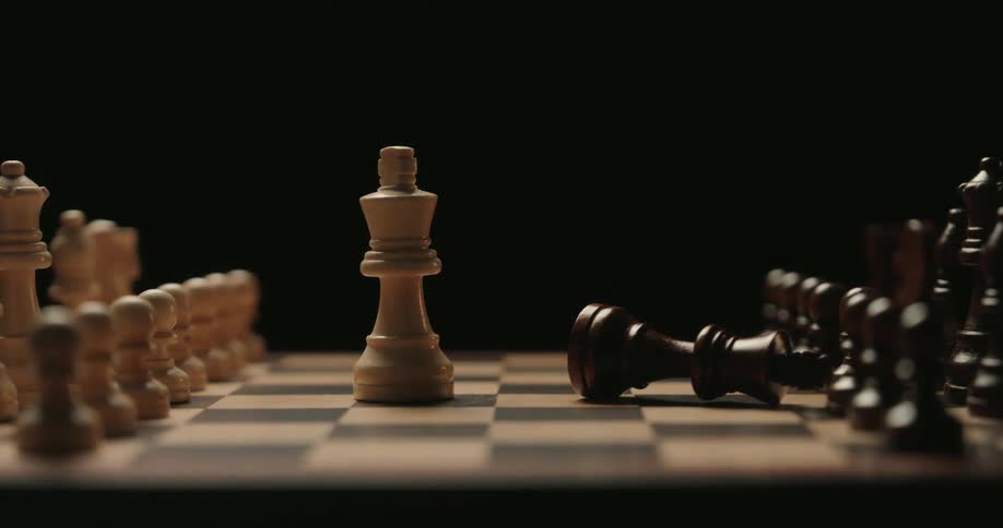 A single chess piece topples over and falls in front of all the other pieces