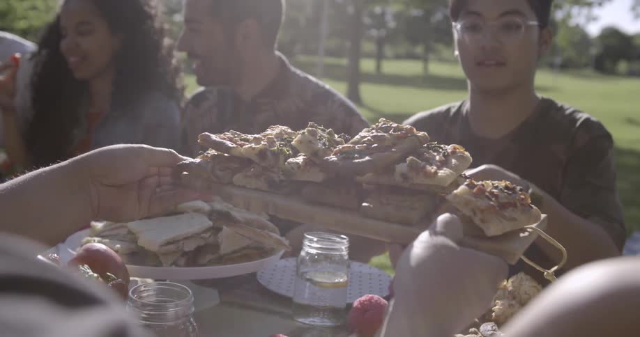 A group of people dine at an outdoor picnic table