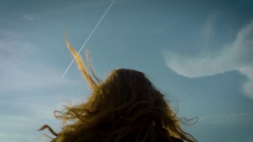 A woman with long red hair turns around quickly and runs away