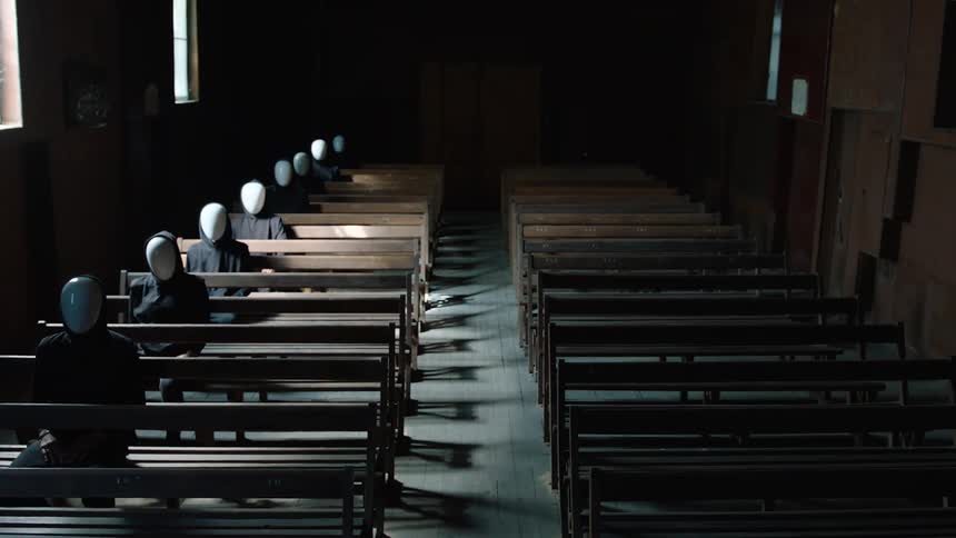 People wearing white masks are sitting in a row in the pews
