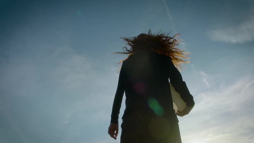 The woman walks while carrying a bowl