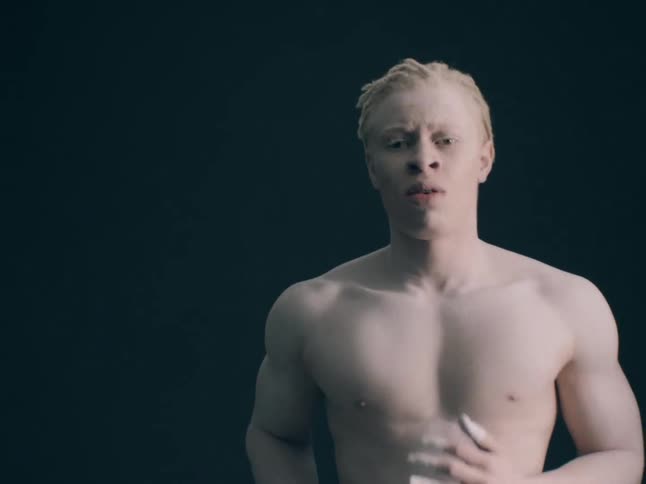 Albino black man running in place indoors